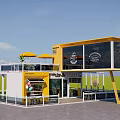 Yellow Container Building Café Restaurant With Large Windows Outdoor Seating And Umbrellas