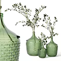 Green Textured Vases With Various Sizes Holding Green Foliage And White Small Flowers