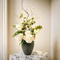 Dark Green Vase With White Hydrangeas Green Leaves And Slender Branches On Patterned Tablecloth