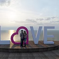 Outdoor Garden Ornament Featuring LOVE Letters Pink Heart And Couple By Sea Sunset View