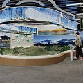 Cultural Center Interior With Visitors Exploring Exhibition Murals Digital Screens And Decorative Flags