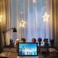 Laptop Screen Showing City Night View On Desk With Marvel Figurines Star Lights White Curtains