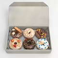 Assorted Donuts Decorated With Chocolate Fruits And Cookies In A Box