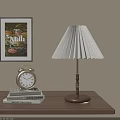 Pleated White Shade Table Lamp With Wooden Base Near Alarm Clock And Books On Table