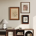 Abstract Paintings on Wall with Brown Frames in Interior with Bookshelf Lamp and Open Book