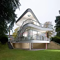 Modern Detached Villa With White Exterior Balcony Staircase Green Lawn And Trees