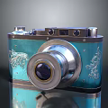 Vintage Camera With Blue Body Silver Lens And Decorative Floral Patterns