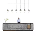 Modern Marble Reception Desk With Receptionist Standing Behind Hanging Pendant Lights And Potted Plant