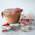 Woven Storage Basket with Pink Beige Pillows beside Books Scented Sticks Fragrance Bottles Small Decor