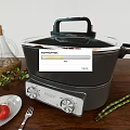 Modern Electric Kitchen Cooker With Olive Oil Bottle Fresh Tomato And Asparagus On Wooden Table