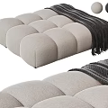 Modern Upholstered Ottoman with Round Tufted Design and Cozy Striped Blanket alongside Decorative Balls