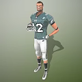 Man In Green Football Jersey With Number 12 Holding Helmet And White Pants