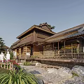 Traditional Garden Space With Thatched Roof Architecture Stone Path Green Plants And Pedestrians