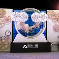 Creative Exhibition Display Featuring Multiple Gears Clocks And Blue Window Design