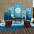 Traditional Cultural Display Setup With Blue Backdrops Chinese Characters Wooden Table And Plants
