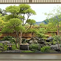 Traditional Japanese Garden With Stone Lanterns Bamboo Fence And Green Trees