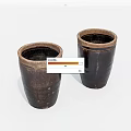 Two Rustic Dark Brown Ceramic Vessels With Cylindrical Shape And Textured Surface