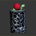 Small Green Plant With Red Top In Black Pot Featuring White Circular Patterns