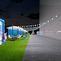 Scenic Outdoor Event Space With Triangular Tent Wooden Deck Tables Chairs Umbrellas And Grassy Area