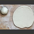 Homemade Fresh Dough and Rolled Out Crust on Floured Wooden Board