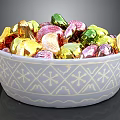 White Decorative Bowl With Snowflake Pattern Filled Colorful Gold Green Pink Wrapped Candies