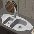 Stainless Steel Kitchen Sink With Faucet Wooden Cutting Board Paper Towel and Pears on Countertop