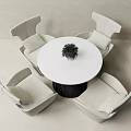 Modern Round Table White Top Black Base And Four Cushioned Ivory Chairs With Small Plant