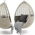 Rattan Egg Shaped Hanging Chair With Gray Cushions And Fringed Blanket