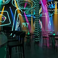 Modern Bar Interior With Neon Lights Bar Counter Tables Chairs And Futuristic Decor