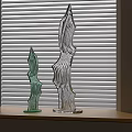 Decorative Glass Ornament Set With Wavy Shapes On Wooden Shelf By Window Blinds
