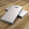 Silver Mobile Power Banks With USB Ports And Digital Displays On Wooden Tabletop