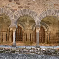 Cartoon Scene of Ancient Stone Arches with Carved Pillars and Wooden Doors in Medieval Courtyard