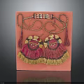 Pair Of Decorative Tassel Ornaments With Embroidered Design On Pink Display Board
