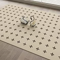 Beige Square Rug With Black Star Patterns And Silver Items On Wooden Floor