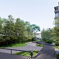 Residential Landscape With Winding Paved Pathway Lush Green Trees And Modern Building