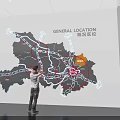 Person Viewing General Location Map With Roads And Area Markers On Wall