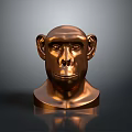 Bronze Colored Monkey Head Sculpture on Dark Background With Reflective Surface