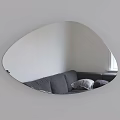 Oval Mirror with Lighted Edge Reflecting Gray Sofa and Pillows in White Wall Interior