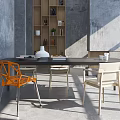 Modern Dining Table Set With Orange And Beige Chairs Concrete Wall And Shelves