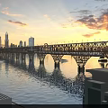 Steel Truss Bridge Carries Cars And High Speed Train At Golden Sunset Over Calm River