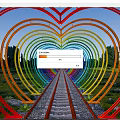 Rainbow Colored Heart Shaped Pergola with Central Pathway Green Trees and Grassy Area