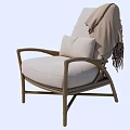 Comfortable Rattan Leisure Chair With Light Gray Cushion And Fringed Blanket For Cozy Home Use