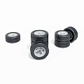 Black Tires With Silver Rims Stacked In Multiple Piles On White Background