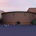 Rusted Circular Building With Surrounding Old Buildings Square People And Trees