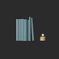 Stacked Light Blue Books with Small Green Decor Piece on Gold Base