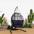 Outdoor Black Woven Hanging Chair With Blue Cushion Green Plants And Stone Decor