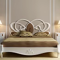 Classic Double Bed With White Carved Headboard Brown Bedspread Patterned Pillows Nightstands And Table Lamps