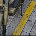 Classic Vintage Beige Leading Motorcycle With Black Seat On Gray Yellow Striped Platform