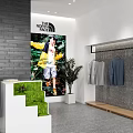 The North Face Clothing Store with Hanging Apparel Poster Display and Green Plants
