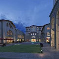 European Style Commercial Street Evening View with Arches Buildings Lawn Stone Pavement and Warm Lighting